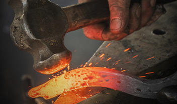 A hammer striking hot steel
