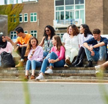 Students sitting on the steps inf ront of Fulton house, Singleton Campus