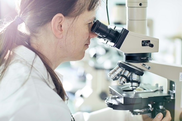 Image of woman looking into microscope