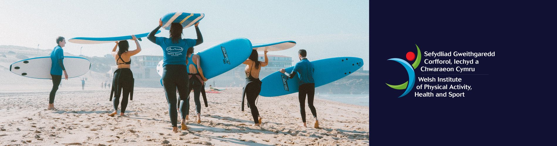 A group of friends make their way to the beach carrying surfboards on their heads