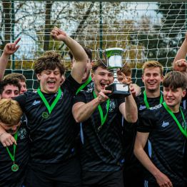 A group of students holding their cup in the air after winning their Intramural 5-a-side football tournament 