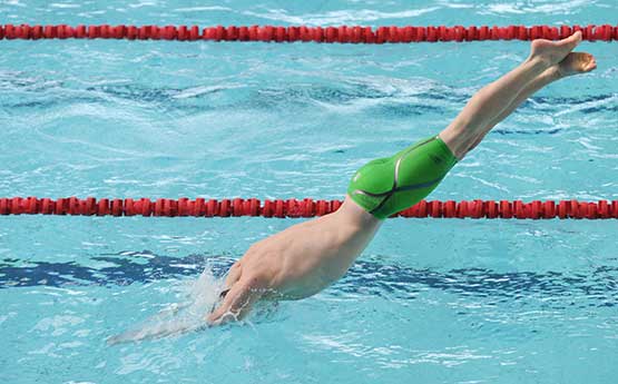 swimmer diving into pool at Wales Varsity