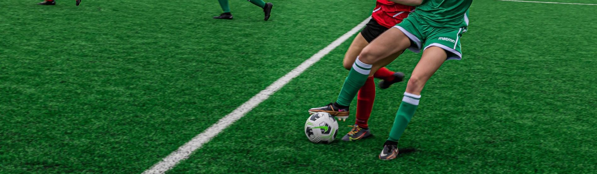 Swansea University women's football player dribbling ball during match