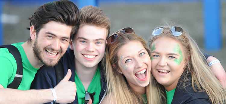 Four Sport Swansea supporters dressed in green and faces painted