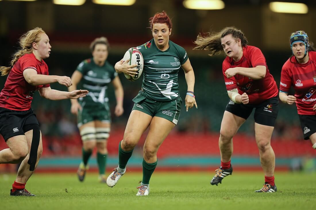 Women's rugby player running with the ball