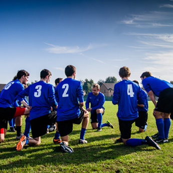 A football team huddle together to receive a brief from the captain