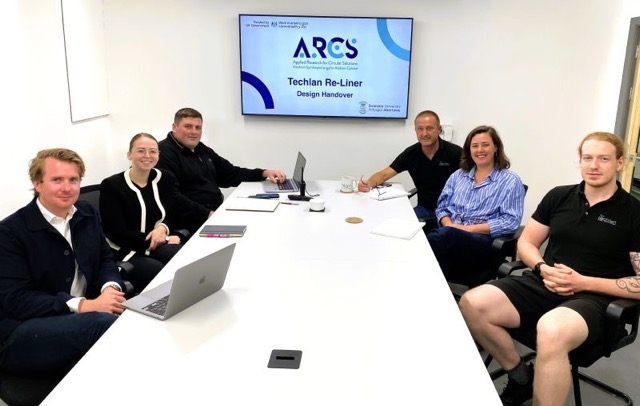 ARCS team sat around the table at a meeting with a company