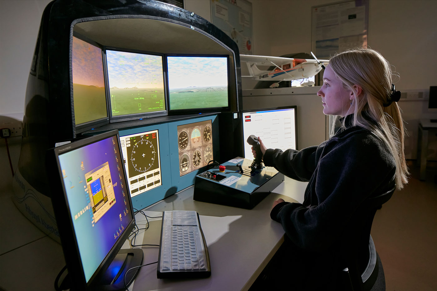 Female student in front of flight simulator