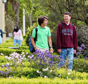 2 male students walking through abbey gardens singleton