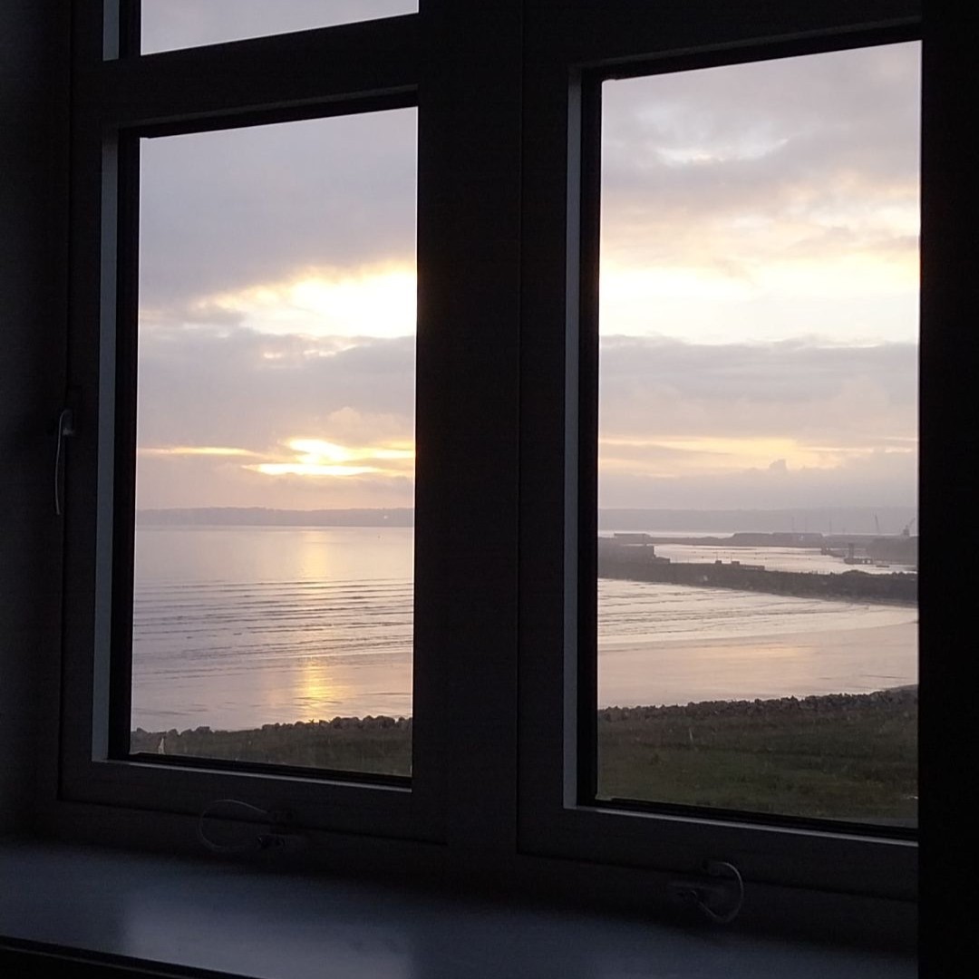 View of the sea from student's dorm window at sunset. 