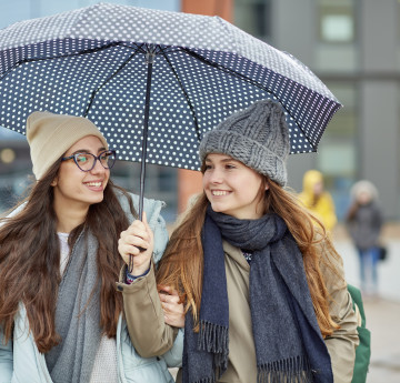 students under an umbrella on a rainy day