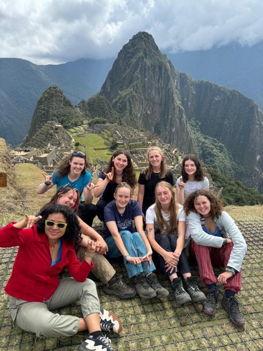 students sitting in front of Machu Picchu