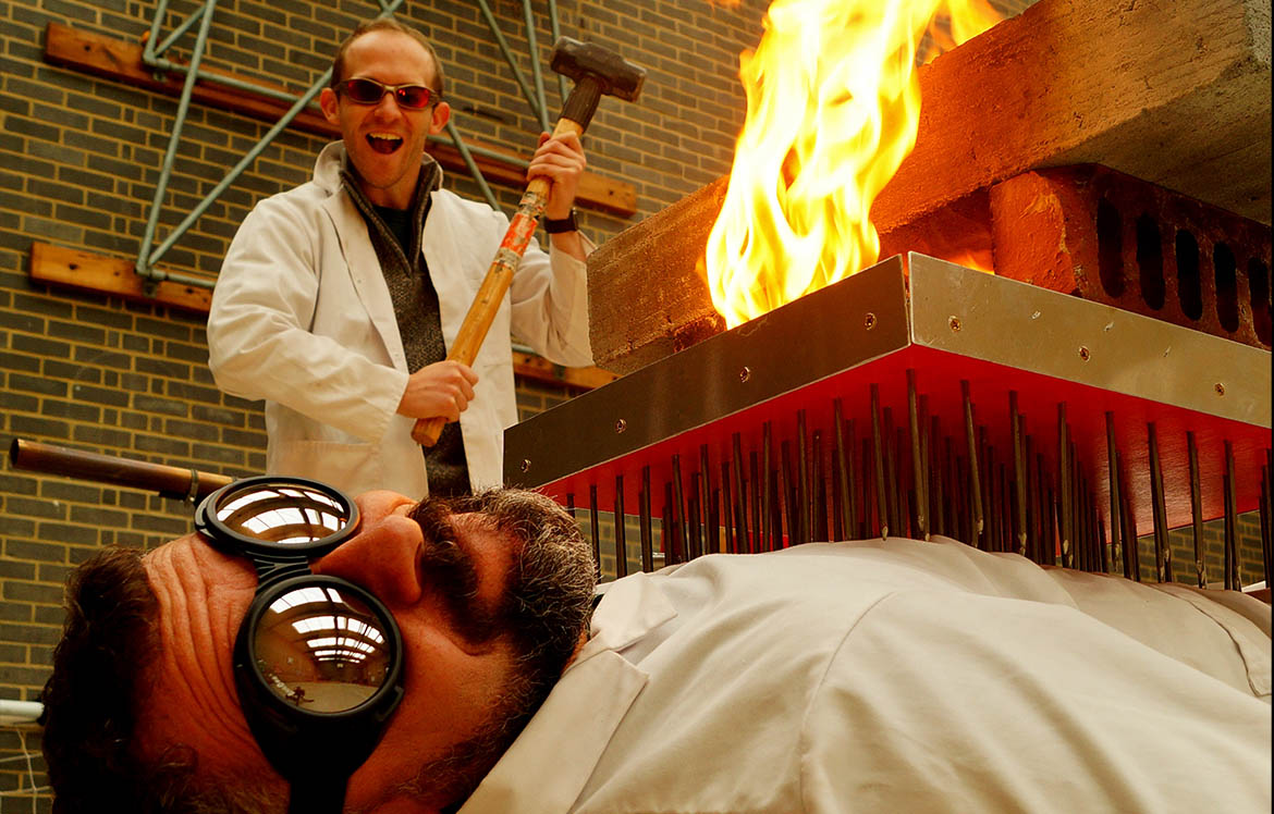 Two scientists in white coats doing dangerous fire experiment