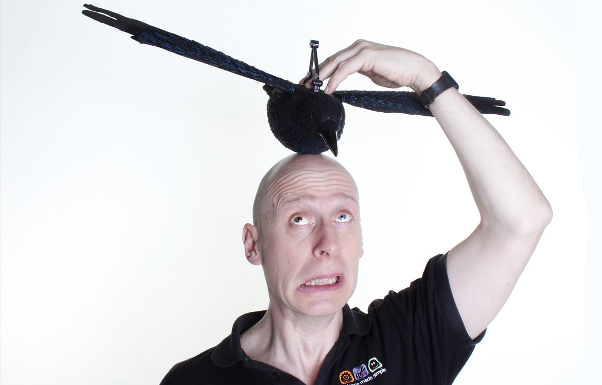 A man with fake bird on his head