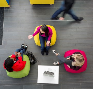Aerial photo of 3 students on colourful chairs