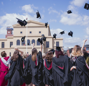 Students graduating and throwing caps in the air