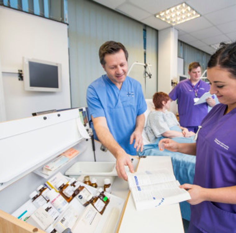 An image of students involved in a nursing practical session.