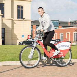 student on a bicycle on bay campus