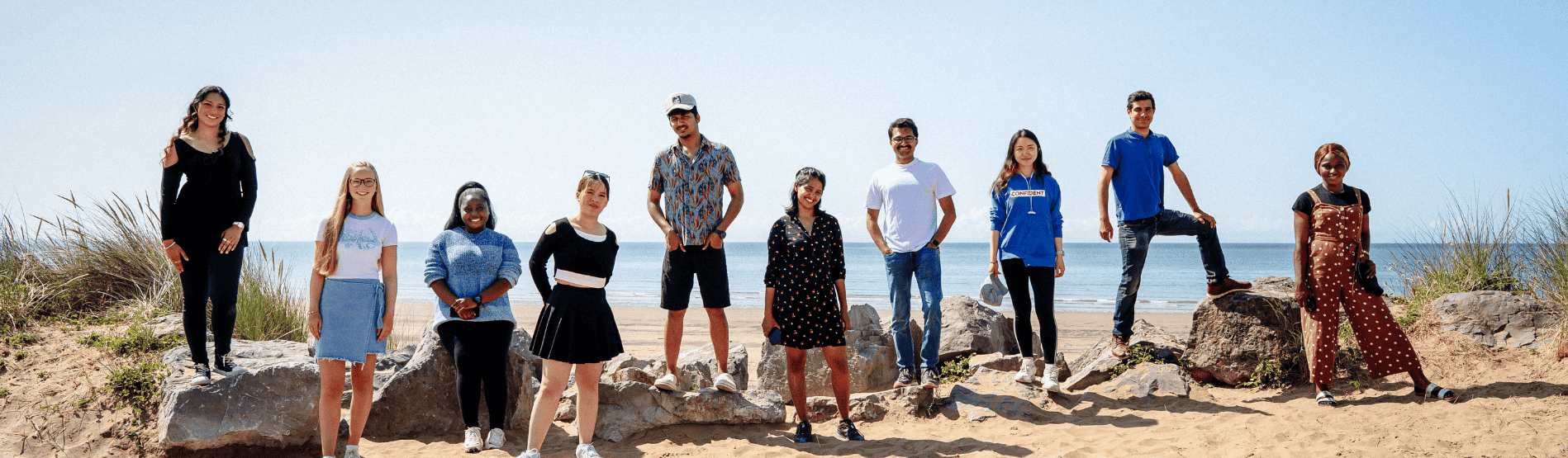 Group of students posting together for a photo at the beach 