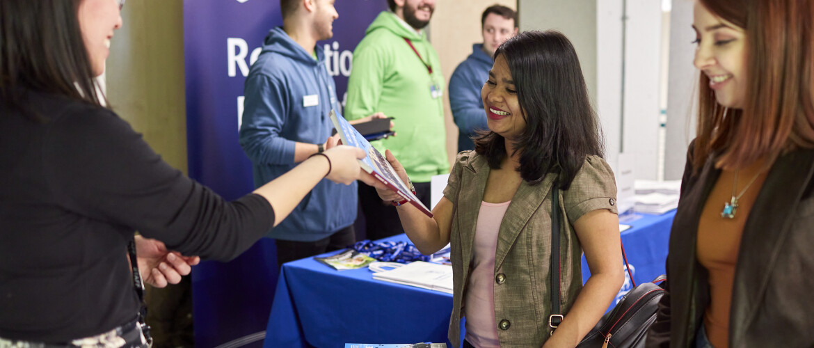 Student speaking to staff at an open day