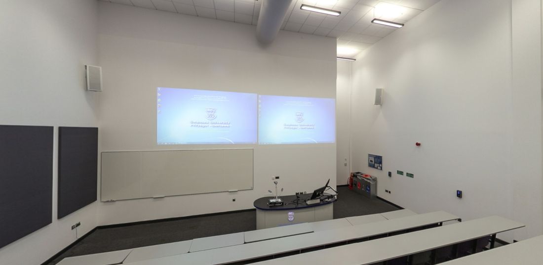 Lecture theatre with tiered seating, dual projectors and teaching desk
