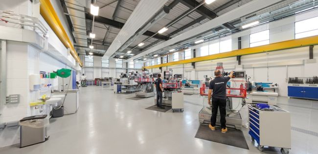 Mechanical workshop with machinery, workstations, and technicians