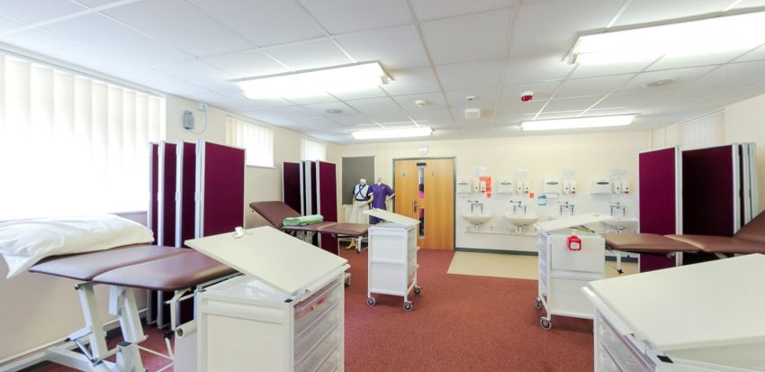 Clinical training suite with examination couches, privacy screens and sinks