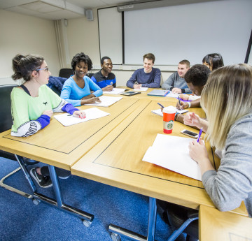Students sitting around a table during a workshop.