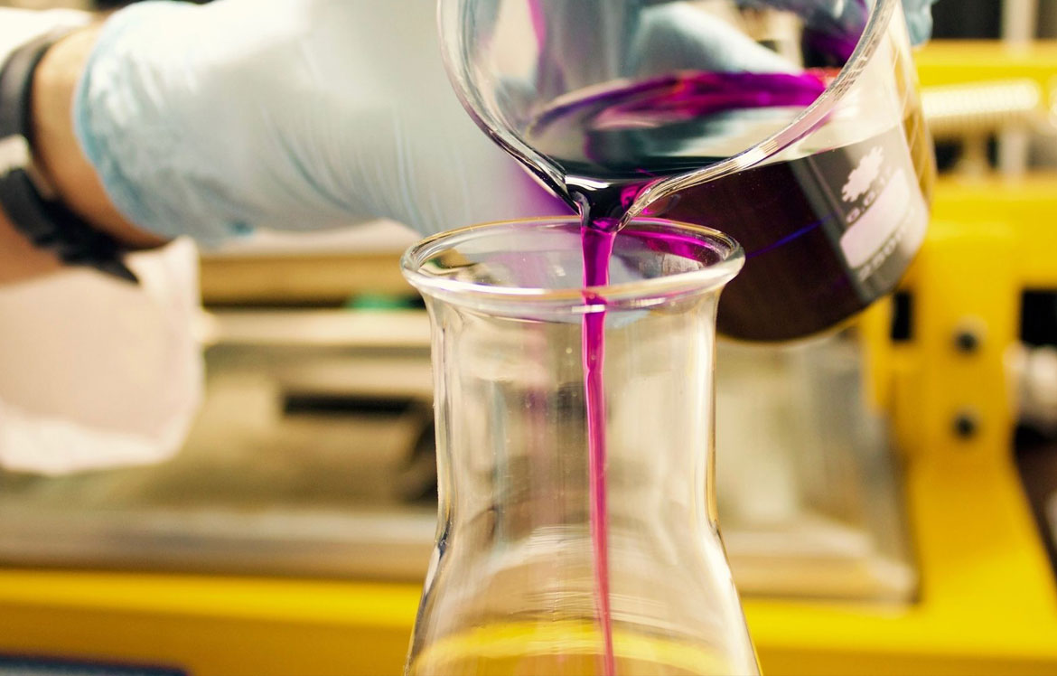 purple fluid being poured into beaker
