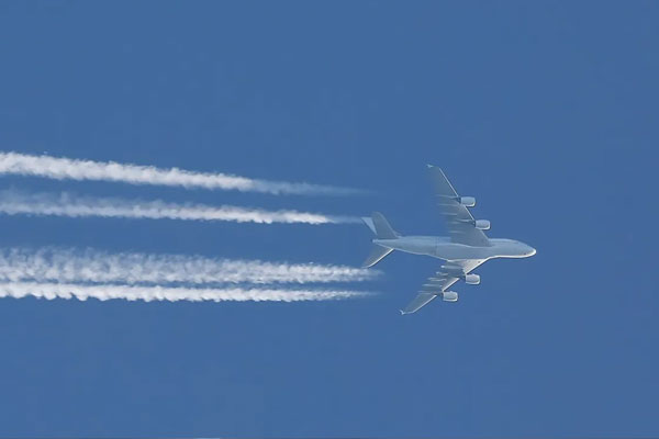 Plane flying with contrails behind it