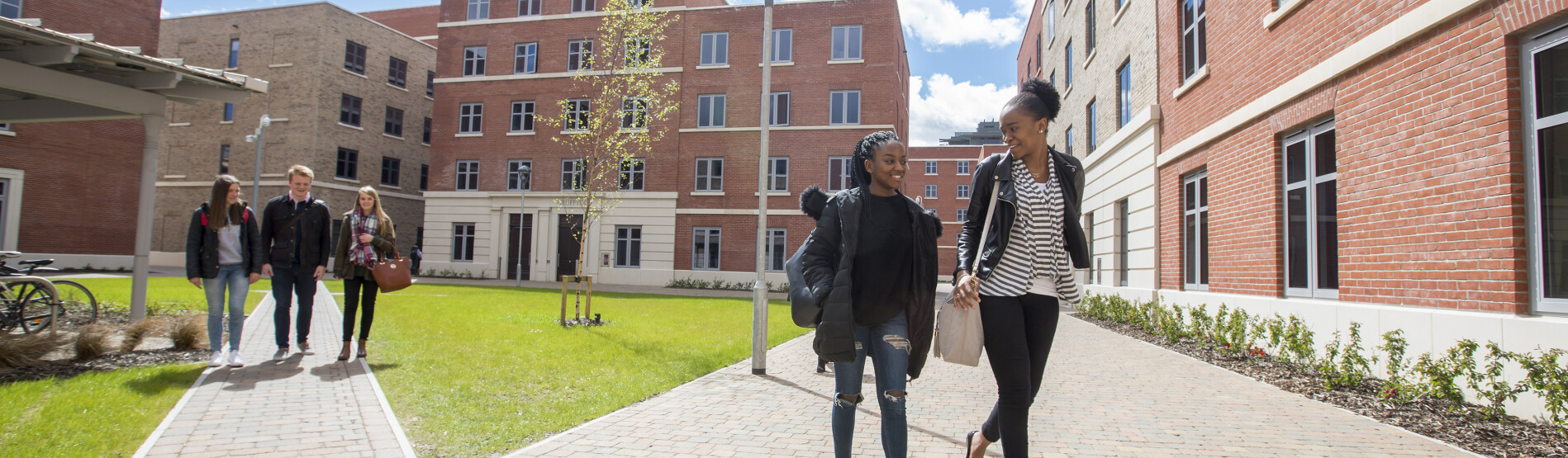 Two people waling through accommodation blocks